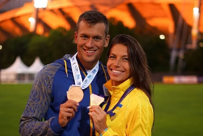 Легкоатлетка тримає у руках біженця