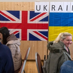 група мігрантів на тлі будинків у Британії