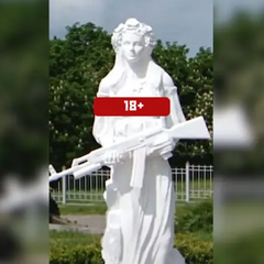 Скульптура оголеної жінки з автоматом