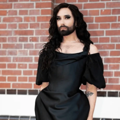 Conchita Wurst in front of the Eurovision logo