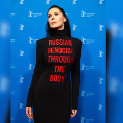 Maria Yefrosynina at Berlinale in dress with slogan about genocide