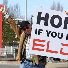 Протестувальники з написом «Не фінансуйте фашистів» навпроти зображення Маска та Tesla