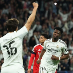 PSG and Real logos on football pitch background