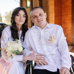 На зображенні дівчина, що тримає руку в руці військового хлопця у реанімаційному відділенні весело посміхаючись