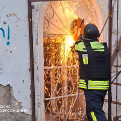 Рятувальники виводять жінку з палаючої будівлі