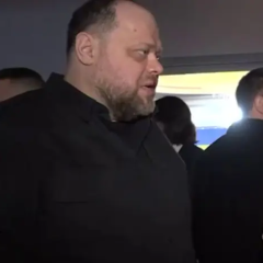 Man with a microphone in front of the Ukrainian Parliament