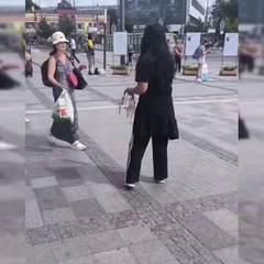 Женщина торгует сине-желтыми лентами у вокзала