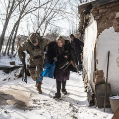 Rescuers evacuate people under shelling