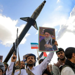 Portrait of Khamenei with burning buildings in the background