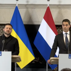 Two people signing agreement with drones in background