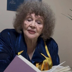 Lina Kostenko with a festive cake in the background