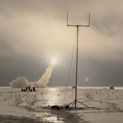 Ukrainian military with rocket launch in background
