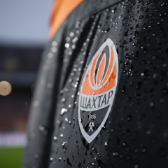 Logos of Shakhtar and Krivbas on the football field background