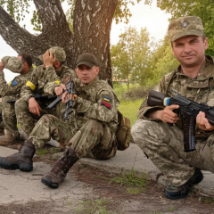 Два военных на фоне разрушенного строения