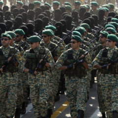 Iranian national flag with American military equipment in the background