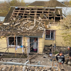Жінка збита уламками, будинок у руїнах