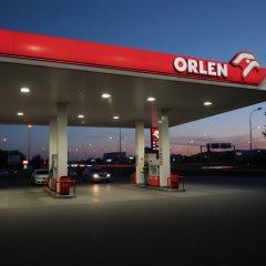 Логотип компании Orlen на фоне польского флага