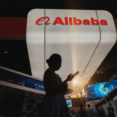 Логотип компанії Alibaba на фоні американського прапора