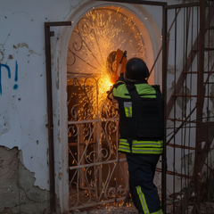 Рятувальники виводять жінку з палаючої будівлі