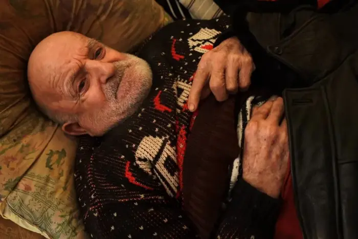 Мужчина с цепью на кровати