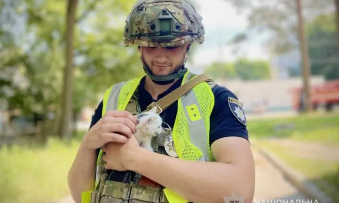 Полицейский спасает котенка после российского удара