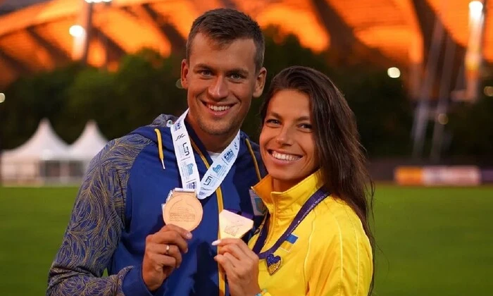 Легкоатлетка тримає у руках біженця