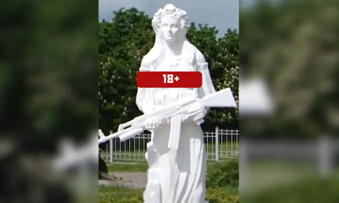Скульптура оголеної жінки з автоматом