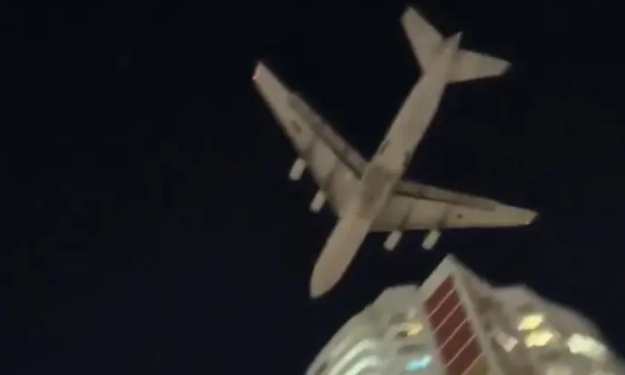 Грузовой самолет низко над постройками