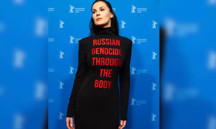 Maria Yefrosynina at Berlinale in dress with slogan about genocide