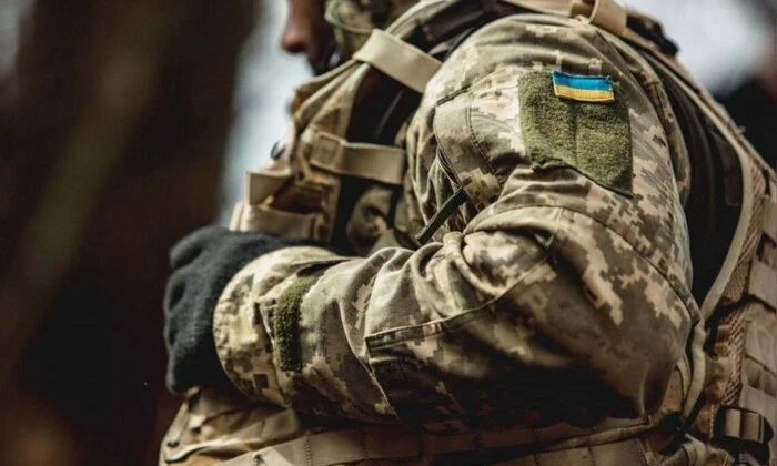 Зображення бійця з війни, якому вибивають борг