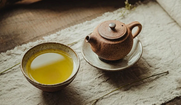 Чашка чаю на тлі зелених листків
