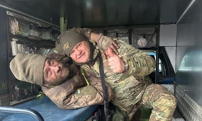 Украинский военный держит двух российских военных