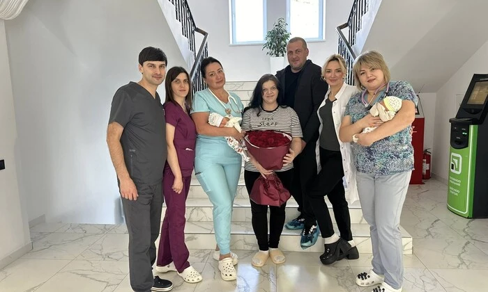Жінка з двійнею на тлі новонароджених