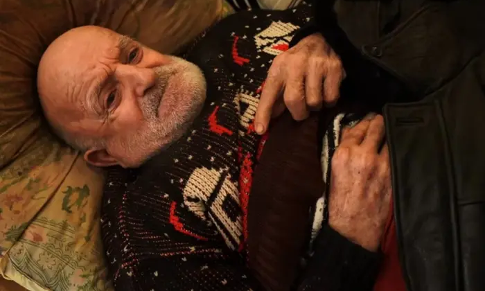 Чоловік з ланцюгом на ліжку