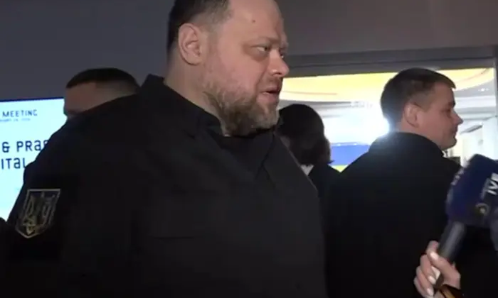 Чоловік з мікрофоном на фоні Українського Парламенту