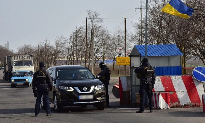 Детективи обшукують автомобіль на блокпосту