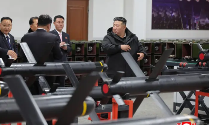 Ким Чен Ин на фоне оружия