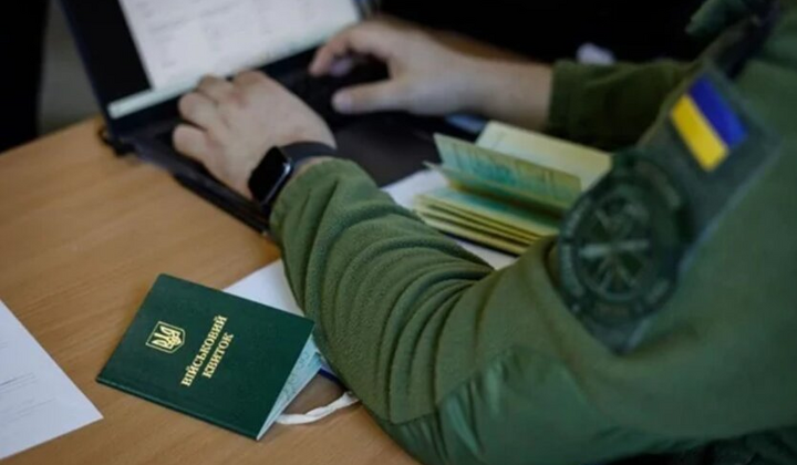 Люди демонструють плакати протесту біля ТЦК
