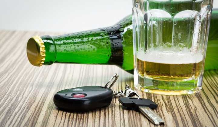 Водитель пьет алкогольное пиво за рулем