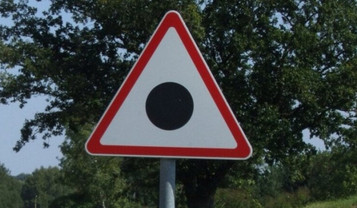 Чорна крапка у трикутнику на дорожньому знаку