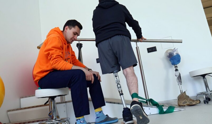 Группа людей спешит через металлические ограждения