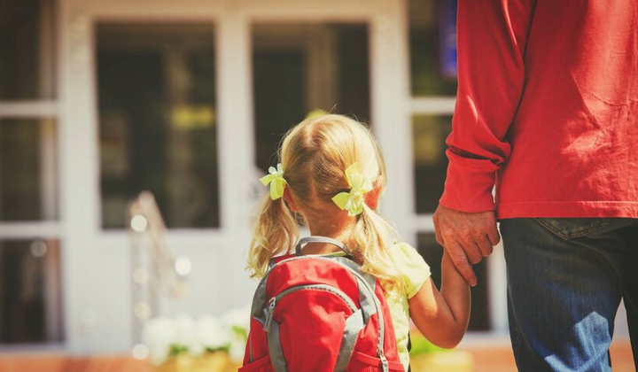 Дитина сумнівно дивиться на школу