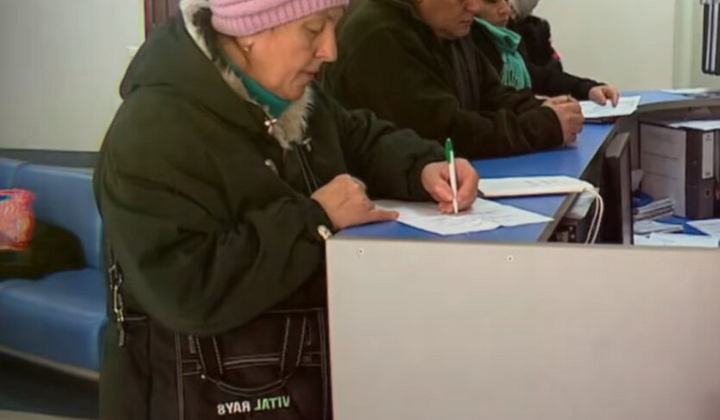 Пенсионер получает деньги в банкомате