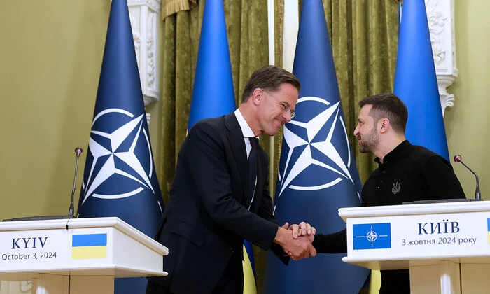 Люди демонстрируют карту Украины на фоне флага НАТО