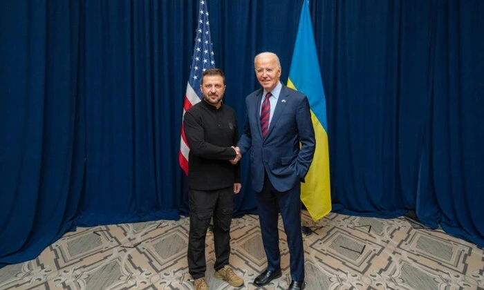 Доларова купюра на фоні прапора України