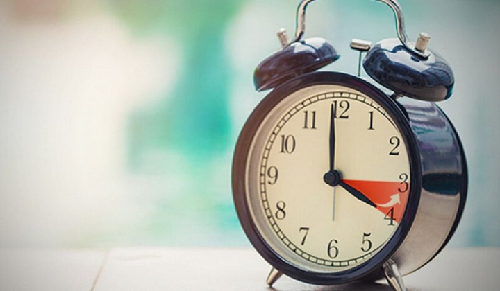 Рука, перекладаючи годинник на літній час.