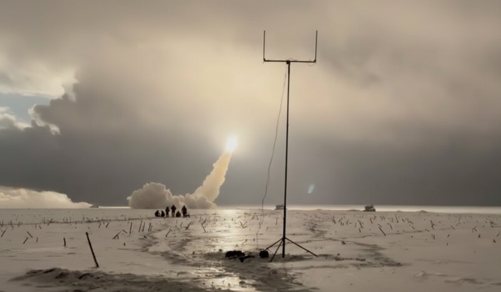 Ukrainian military with rocket launch in background