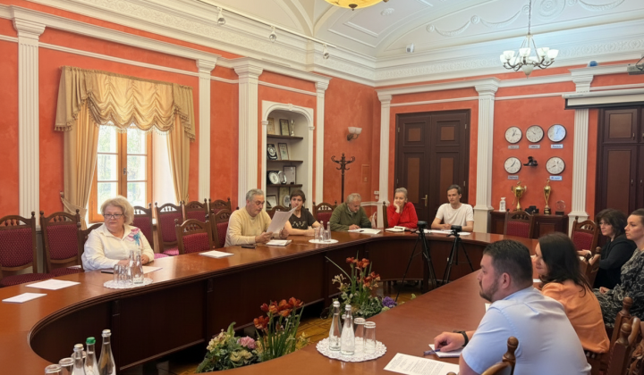 Комісія на фоні будівлі університету