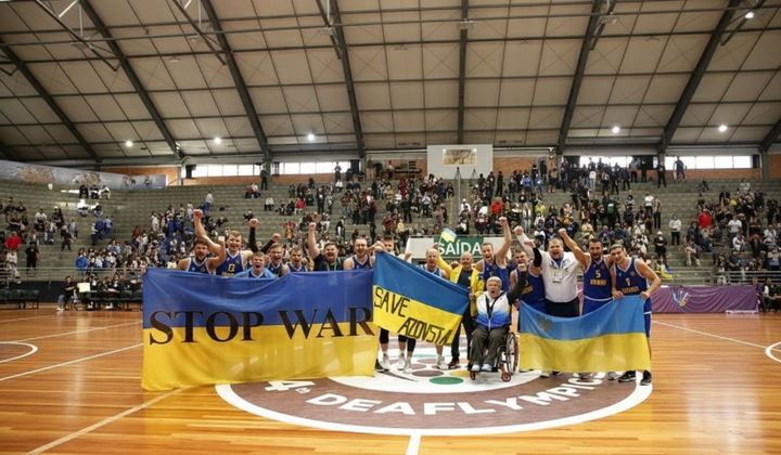 Українські спортсмени на фоні логотипу Дефлімпіаді-2025