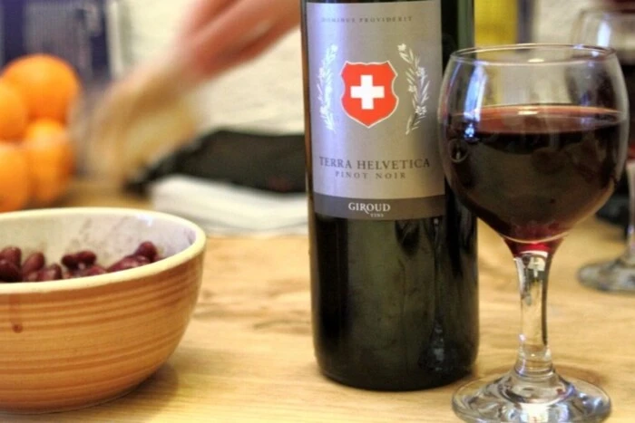 Министр экономики Швейцарии тостует с бокалом вина